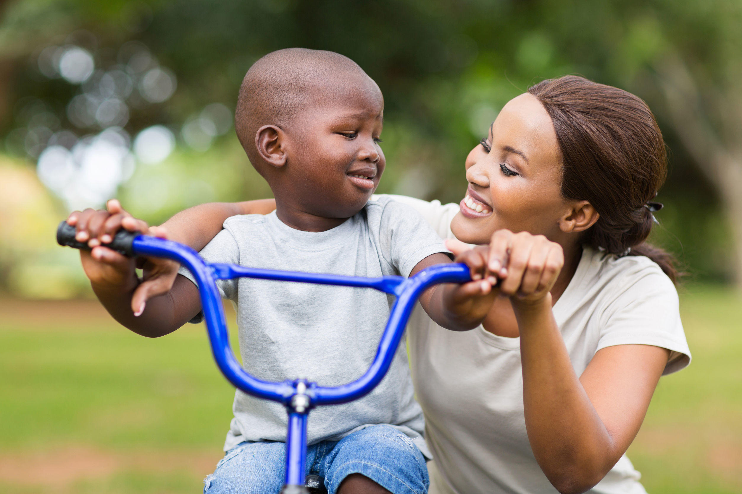 black woman helping her son with bike