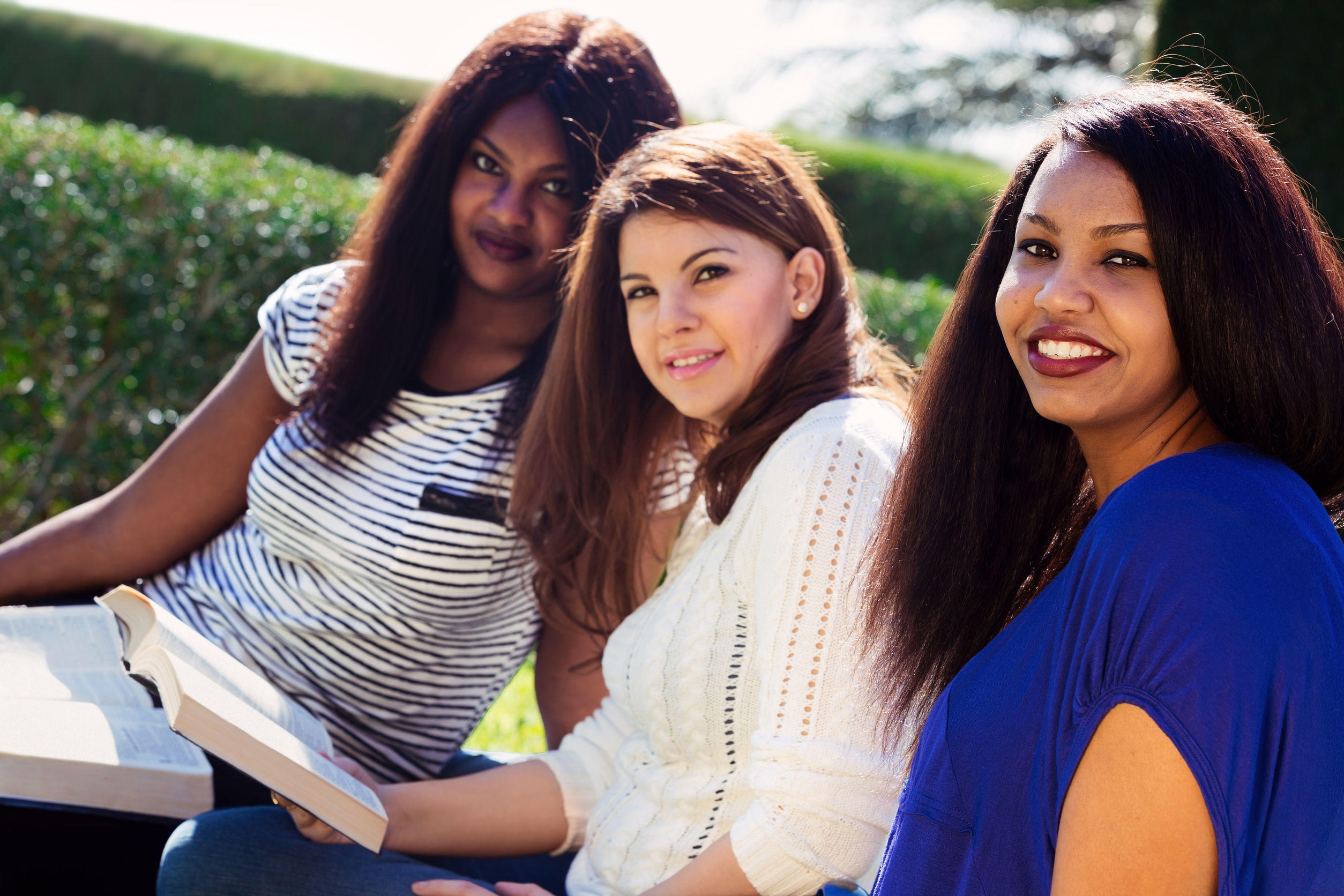 30851213 – three christian girls studying the bible and looking at the camera