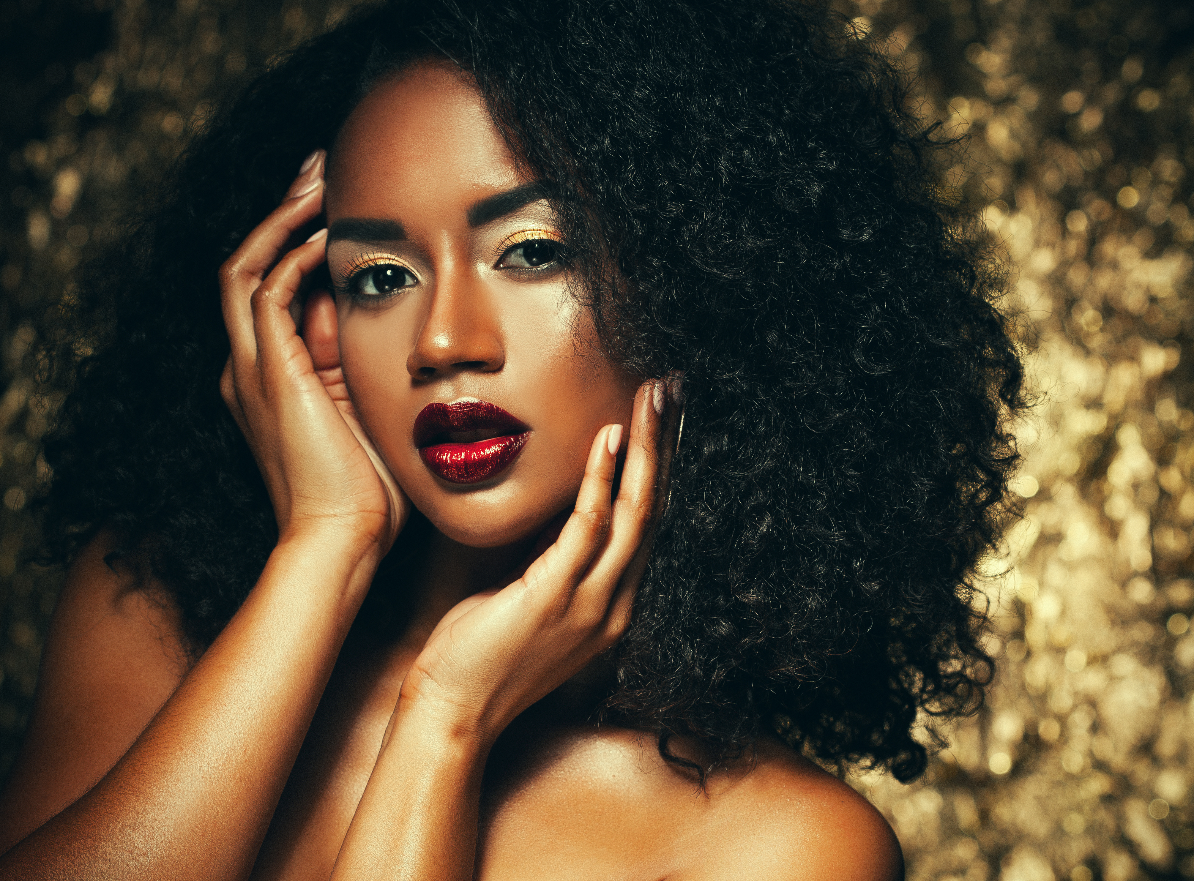 young elegant african american woman with afro hair. Glamour makeup. Golden Background.