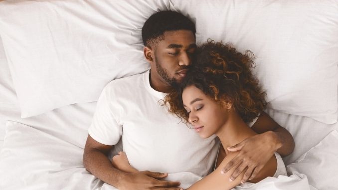 black couple laying in bed